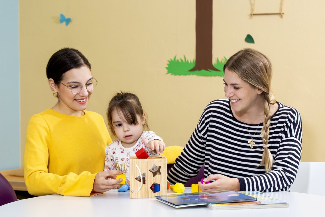Zwei Therapeutinnen mit Mädchen im Sozialpädiatrischen Zentrum